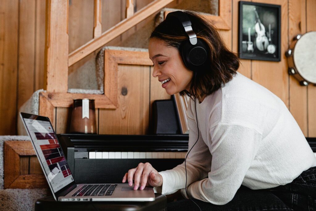 Fejhallgatót viselő tanuló a laptopja előtt, aki az élő beszélgetés során mélyíti el az angol tanulás otthoni eredményeit.